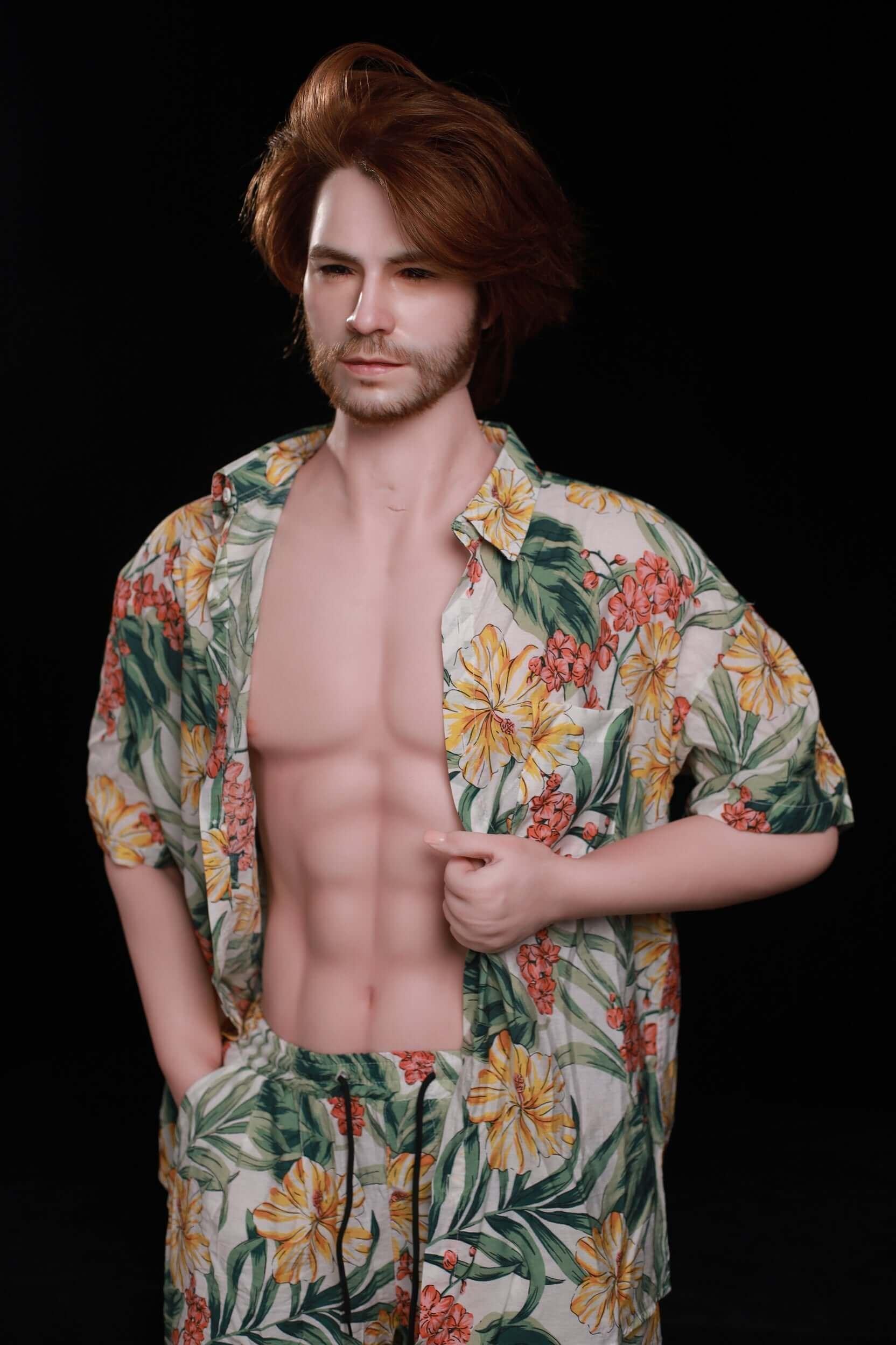Mason 160cm male silicone sex doll standing portrait with auburn layered hair, trimmed goatee, sculpted abs, wearing open tropical floral Hawaiian shirt and matching shorts - dark studio