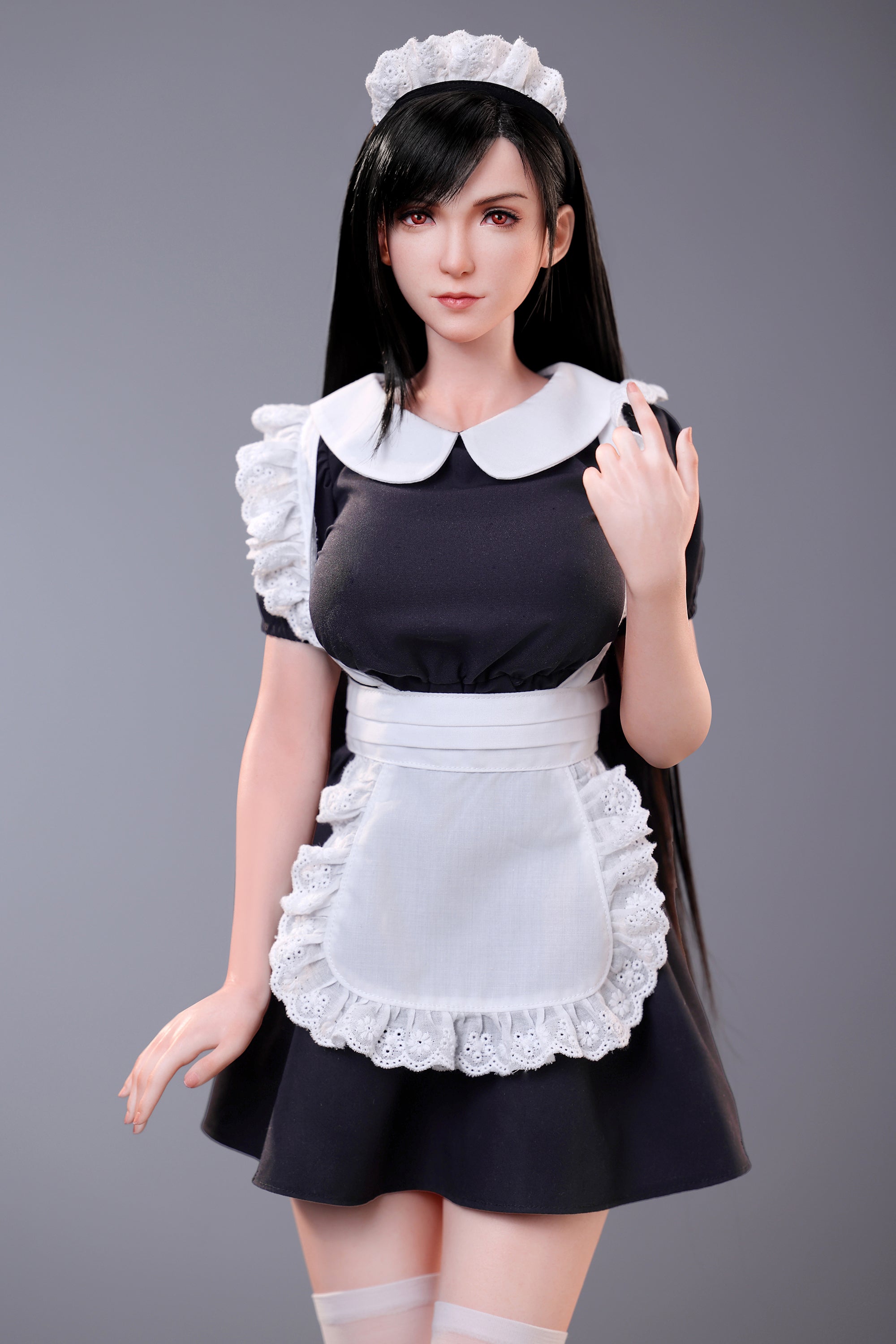 Person wearing a maid outfit with a white apron and headband on a gray background