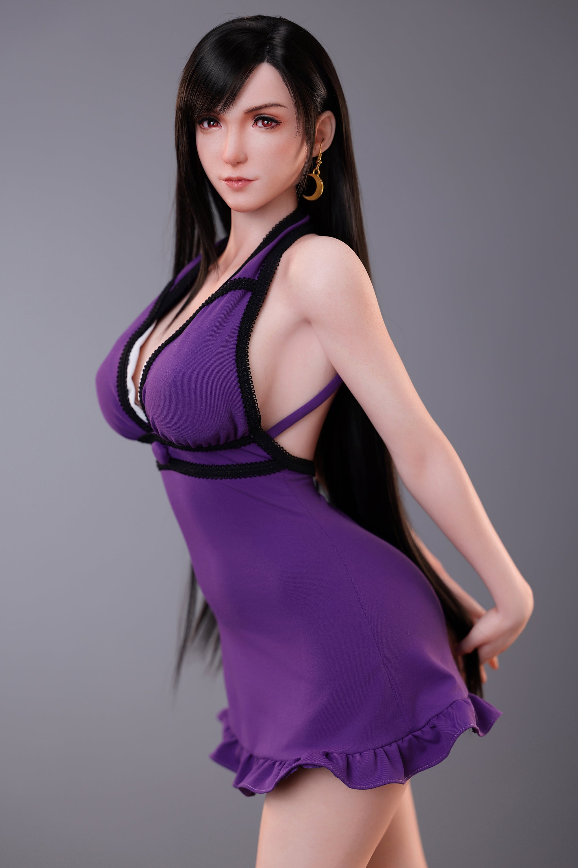 Woman wearing a purple dress with black accents against a gray
background