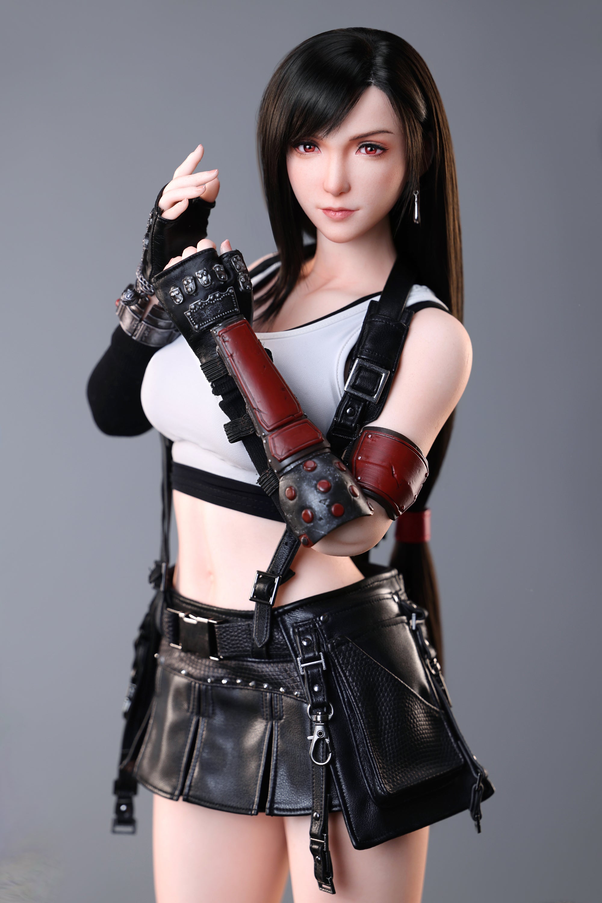Tifa wearing a black and red outfit with gloves on a gray background