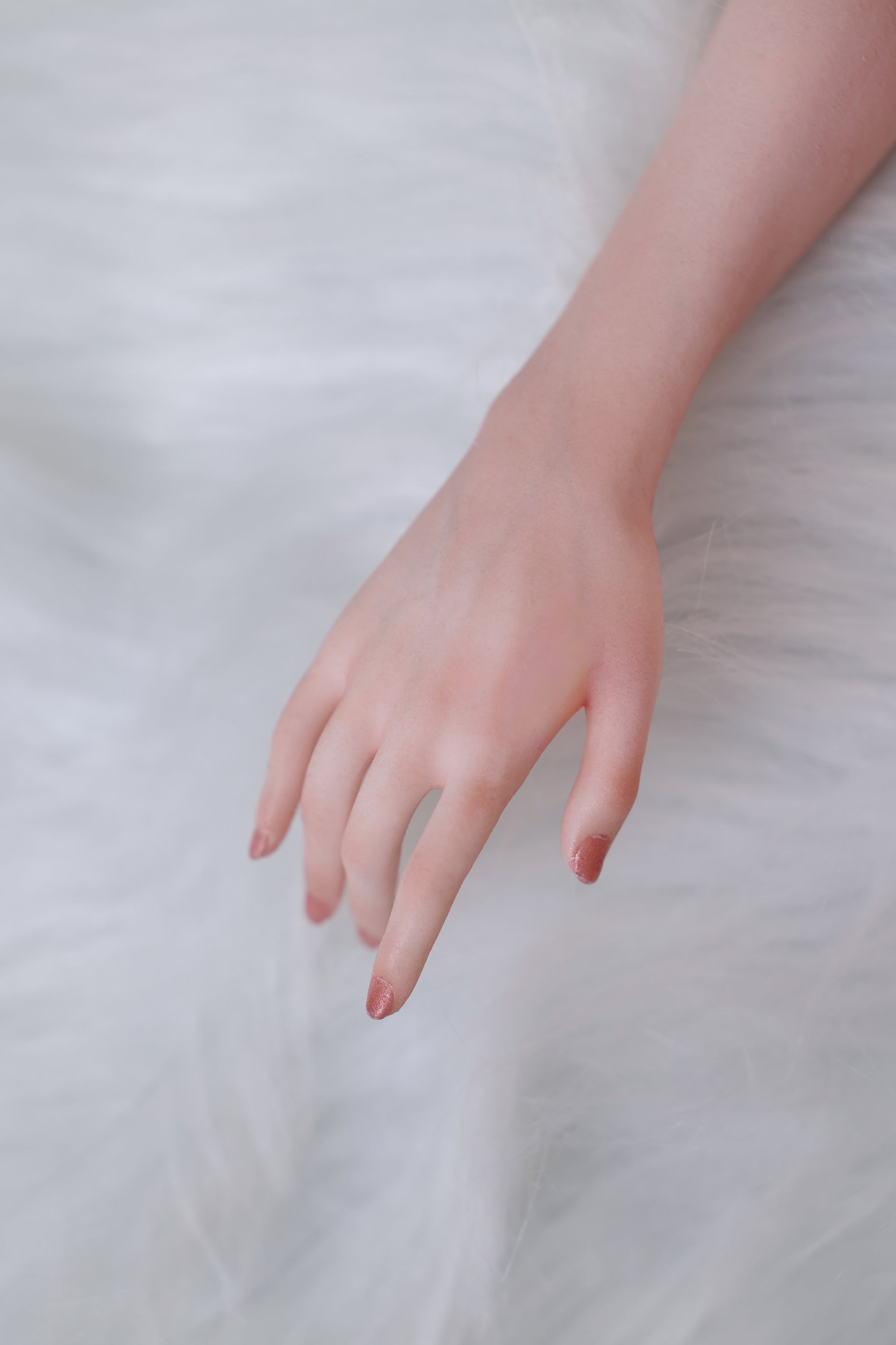 Close-up of a hand on a soft, light-colored fabric background