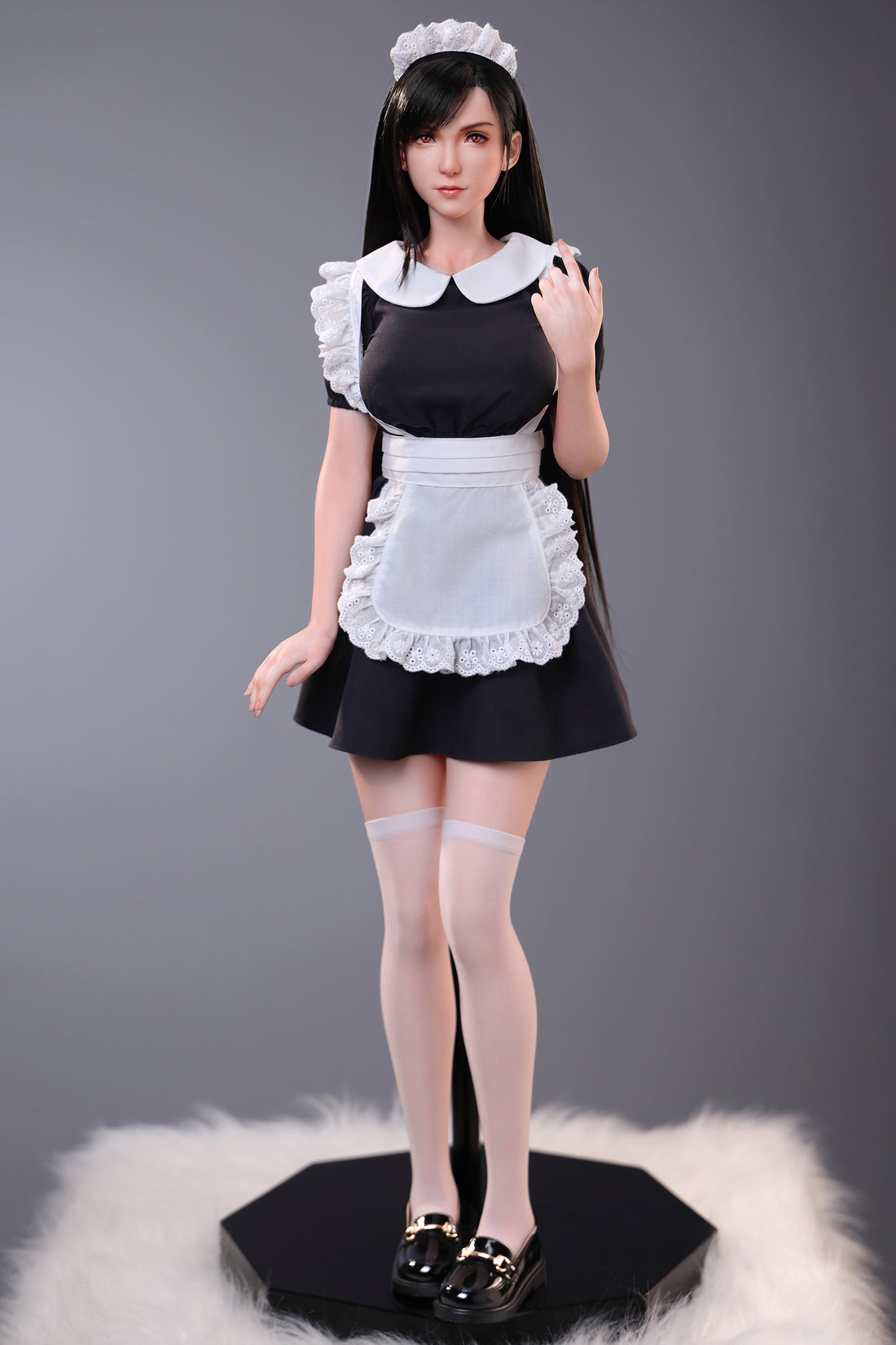 Doll in a maid outfit on a gray background
