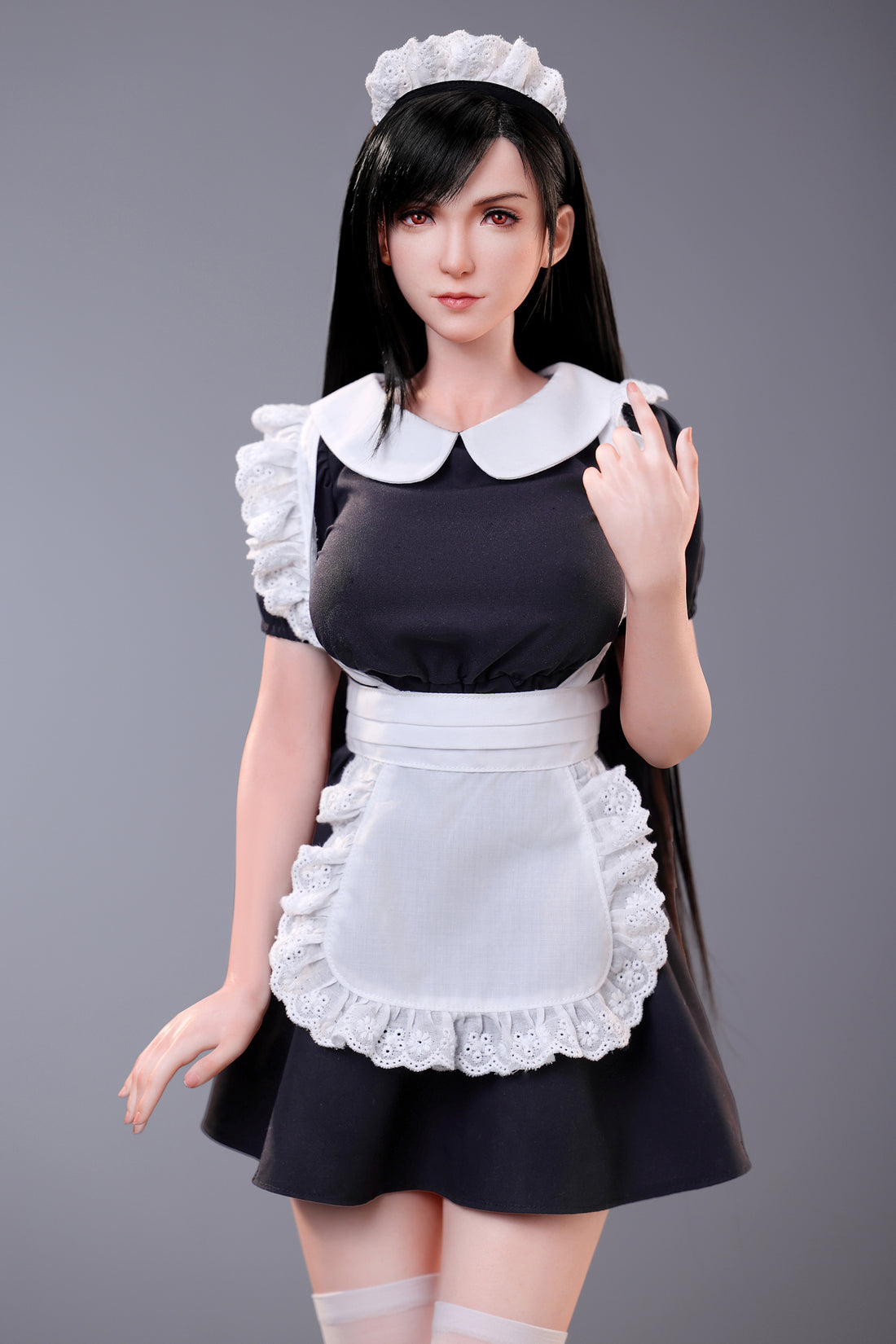 Person wearing a maid outfit with a white apron and headband on a gray background
